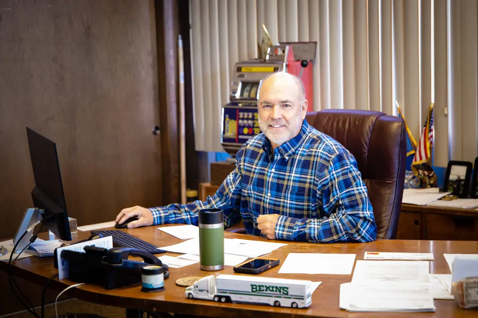 An O'Brien's team member at his desk with a model Bekins truck