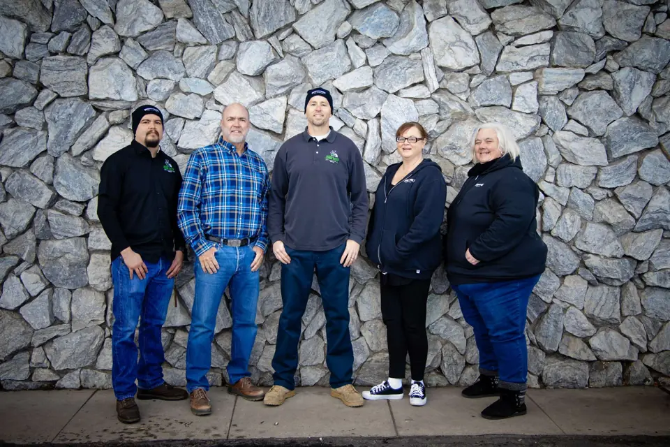 Members of the O'Brien's office and estimating team standing in front of a stone wall