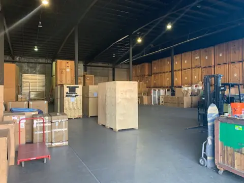 The O'Brien's warehouse floor with crates, vaults and a forklift