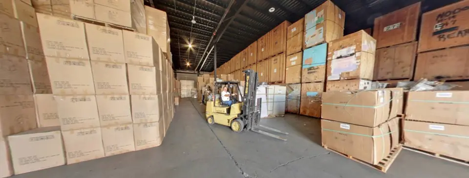 Rows of wooden storage vaults stacked high in the O'Brien's warehouse with a forklift in the aisle